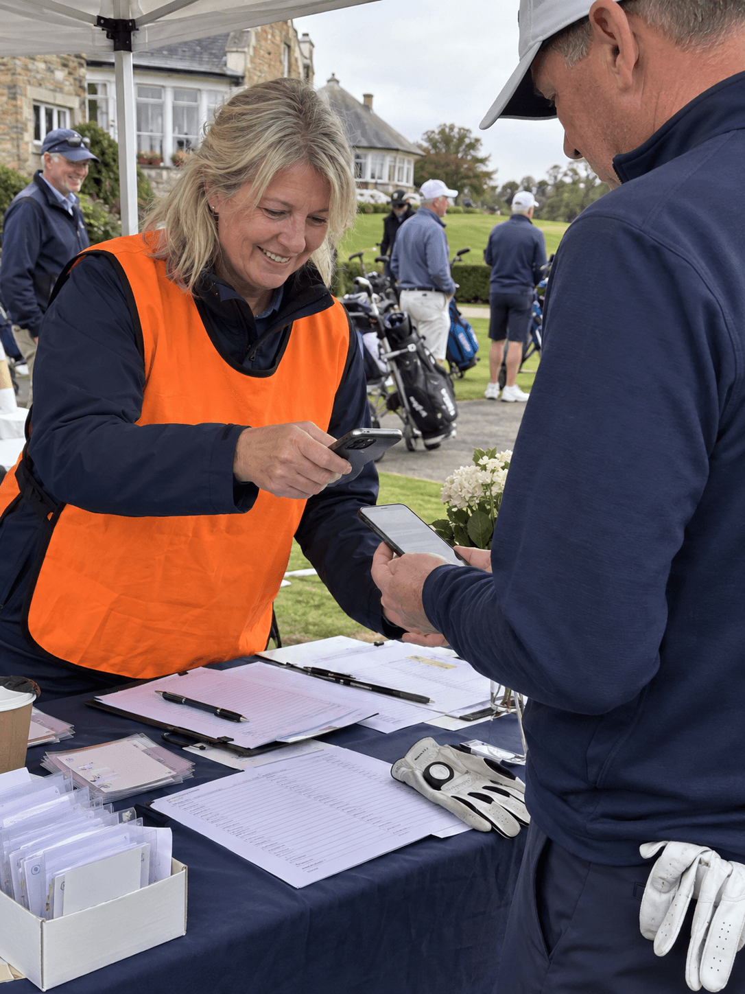 A volunteer checking in a golfer by phone
